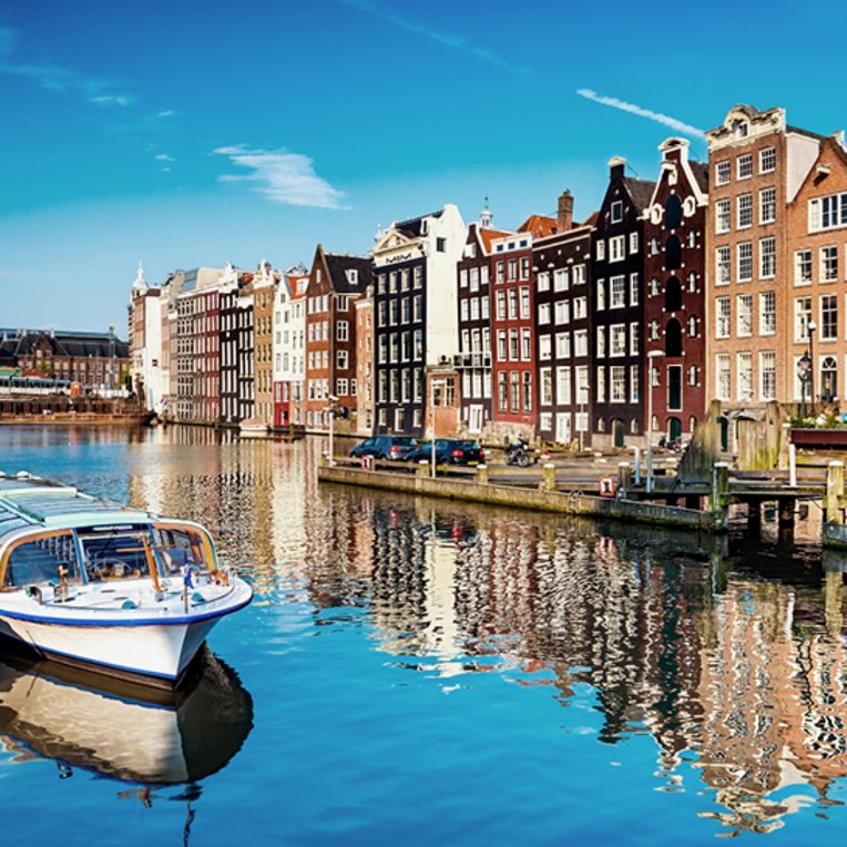 Ein Boot liegt am Kanal in Amsterdam, umgeben von charmanten Gebäuden.