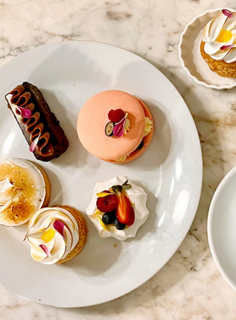  Ein weisser Teller mit verschiedenen köstlichen Desserts aus einer Pariser Patisserie.