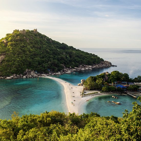 Wunderschöner Strand mit einer kleinen Insel in der Mitte, typisch für die Paradiesinseln in Thailand.