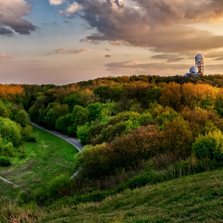 Sonnenuntergang über dem Observatorium in Berlin, mit warmen Farben am Himmel.