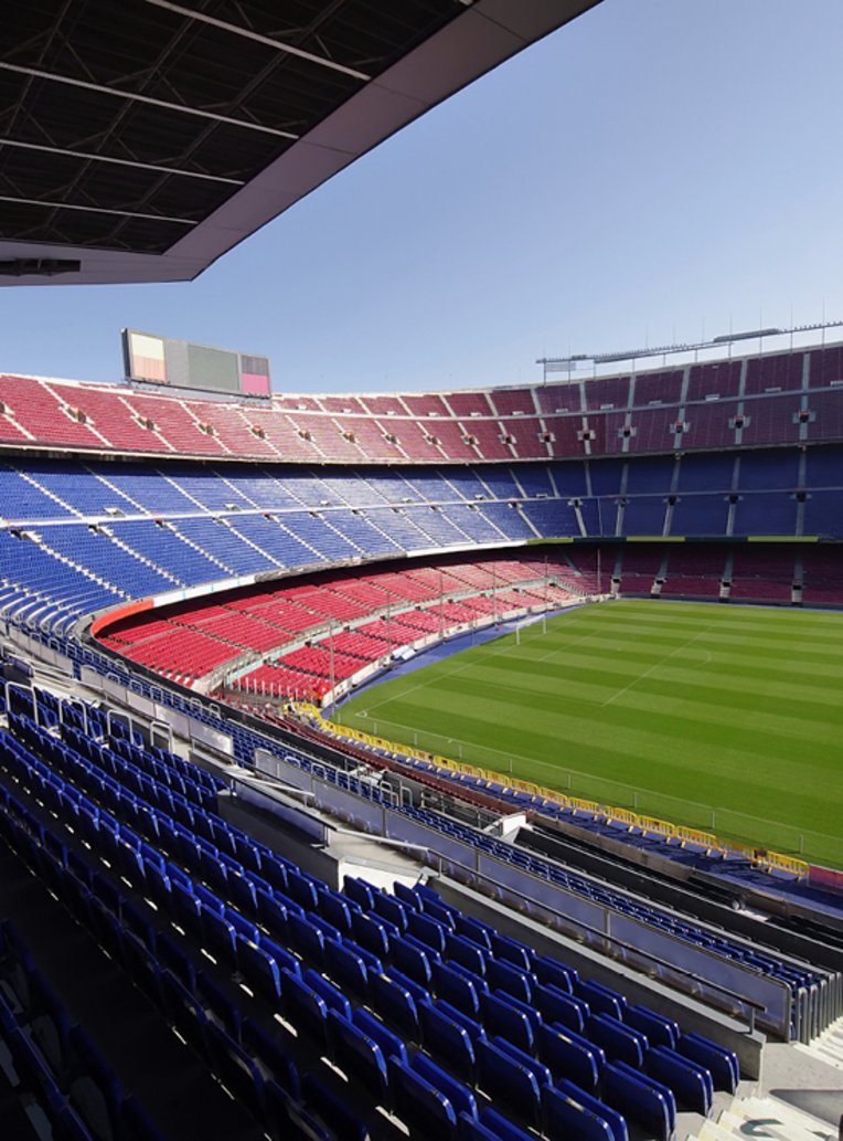 Leeres Camp Nou-Stadion mit blauen Sitzen, das auf eine bevorstehende Veranstaltung wartet.