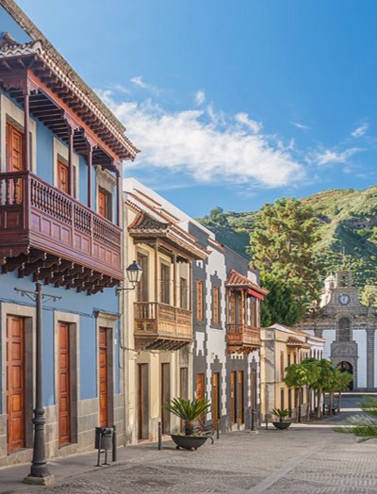 Eine Strasse auf den Kanaren mit einem markanten Uhrturm und einigen umliegenden Gebäuden.