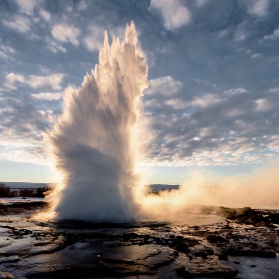 Ein Geysir im Goldenen Kreis Island sprüht Wasser hoch in die Luft.