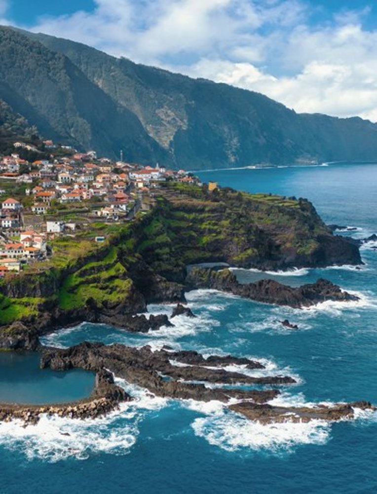 Blick von oben auf das Dorf São José auf der Insel São José in Portugal, umgeben von üppiger Natur und blauen Gewässern.