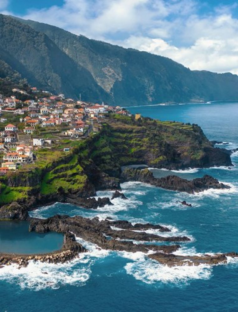 Blick von oben auf das Dorf São José auf der Insel São José in Portugal, umgeben von üppiger Natur und blauen Gewässern.