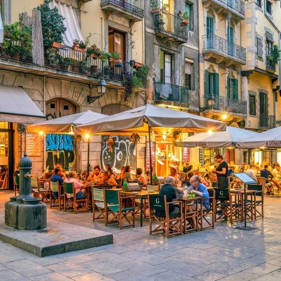 Promenade de la Gracia à Barcelone, juillet 2017, avec des restaurants et cafés animés sur une rue piétonne.