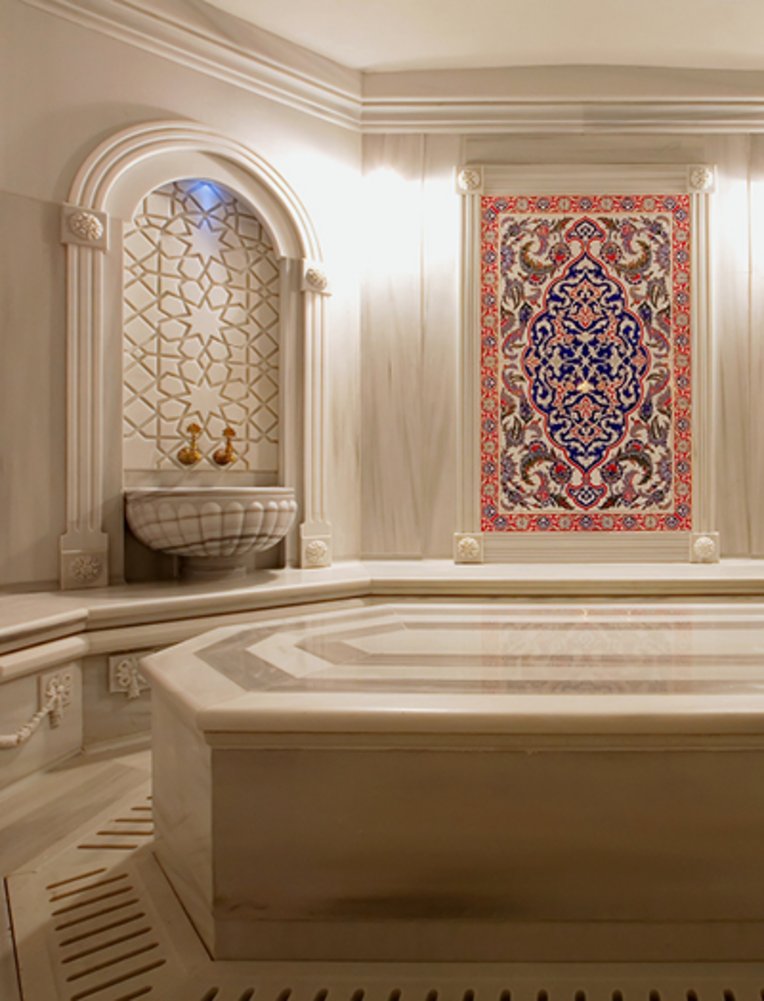 Eine grosse Badewanne in einem Raum mit einem grossen Bild an der Wand, ideal für einen Wellnessurlaub an der türkischen Riviera.