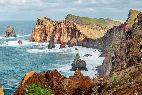 Küstenlandschaft auf Madeira mit Felsen, klarem Wasser und einer Promenade.