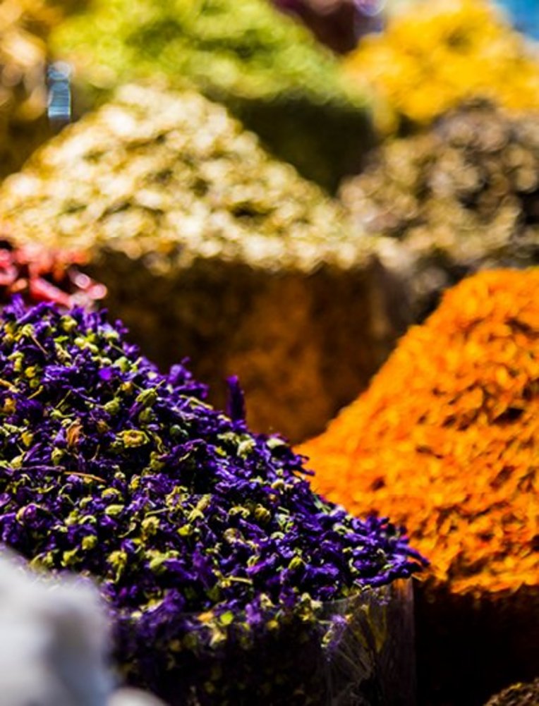 Eine Auswahl bunter Gewürze aus Dubai, die in kleinen Schalen präsentiert werden.