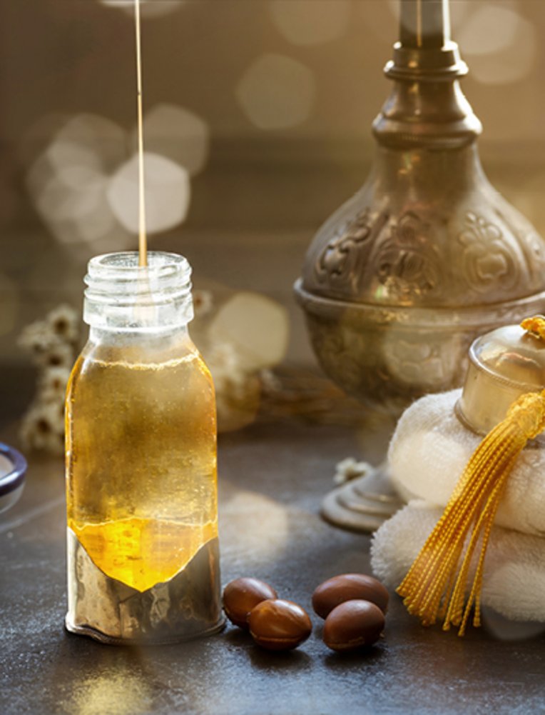 Flasche Arganöl auf einem Tisch mit Früchten in Marokko.