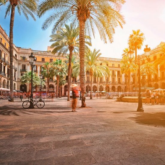 Stadtplatz in Barcelona, Spanien, mit historischen Gebäuden und lebhaften Menschen, die die Atmosphäre geniessen.