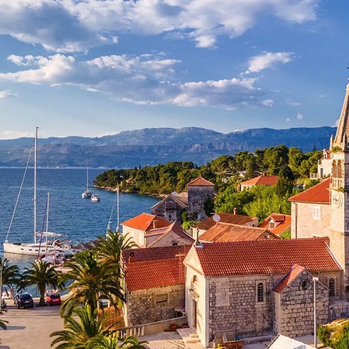 Blick auf die Stadt Kotor in Kroatien, umgeben von Bergen und dem glitzernden Wasser der Bucht.