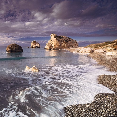 Strand mit Felsen im Ozean und bewölktem Himmel, typisch für die Küste Zyperns.