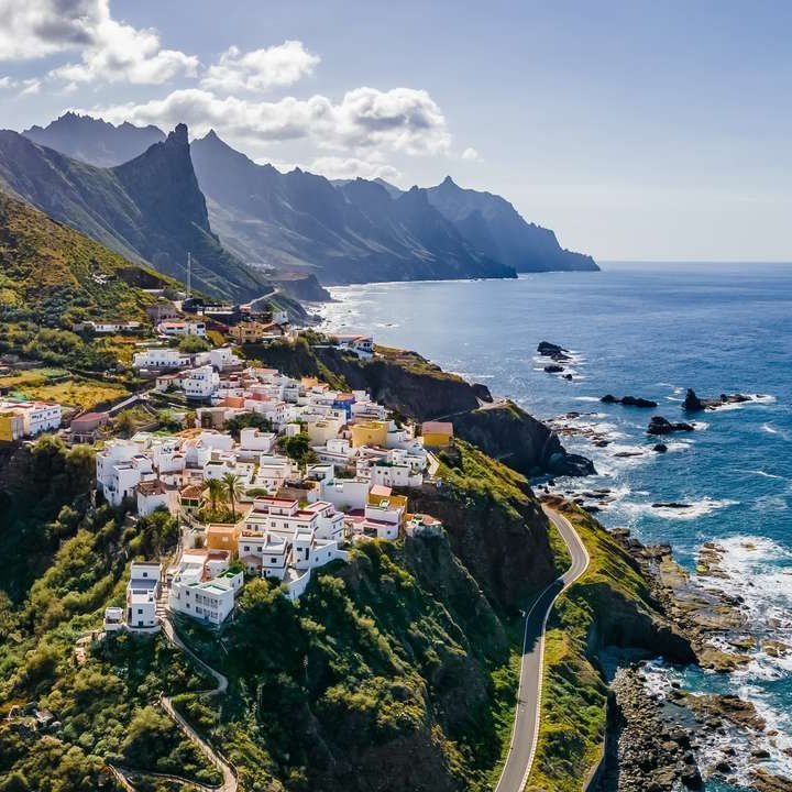 Traumhafte Küstenansicht einer Stadt auf den Kanarischen Inseln, umgeben von klarem Wasser und sonnigem Himmel.