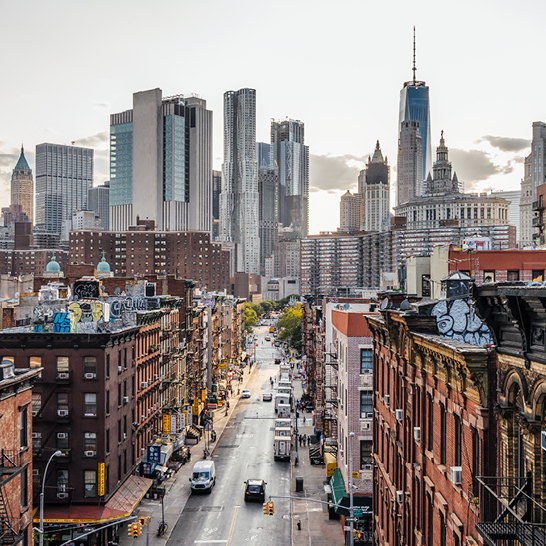 Blick auf die NYC Skyline von einem Dach aus, mit Wolkenkratzern und einem klaren blauen Himmel im Hintergrund.