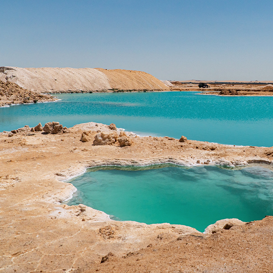 Weite Wasserlandschaft mit einem kleinen Pool in der Mitte, typisch für die Oase Siwa.