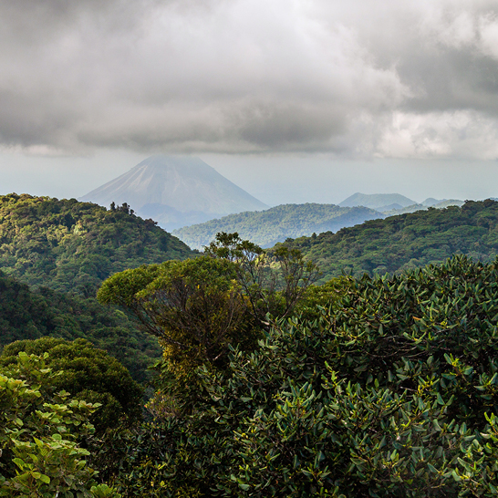 Blick auf eine Bergkette in Costa Rica, umgeben von einem wolkenverhangenen Himmel.