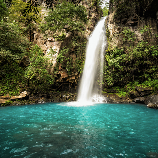  Ein Wasserfall, umgeben von üppigen grünen Bäumen, in Costa Ricas Rincon Vieja.
