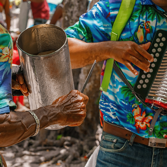 Ein Mann hält eine Blechdose und strahlt Lebensfreude aus, inspiriert von der dominikanischen Tanzkultur.