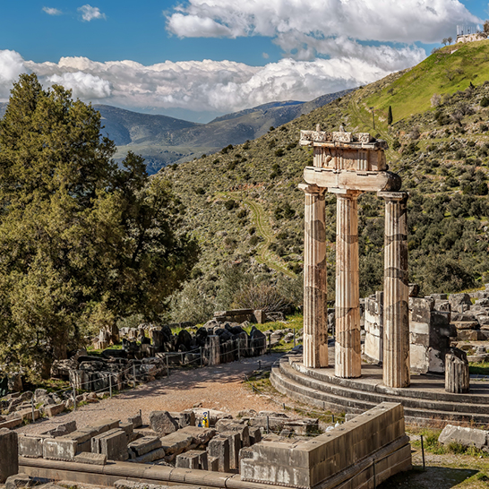 Ruinen von Delphi in Griechenland, umgeben von Bergen und Bäumen, zeugen von der antiken Geschichte und Kultur.