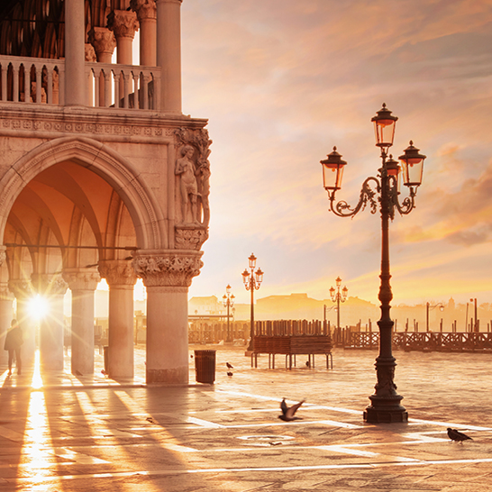 Stadtansicht mit einem beeindruckenden Sonnenuntergang und dem schönen Gebäude der Weltbühne Italien im Vordergrund.