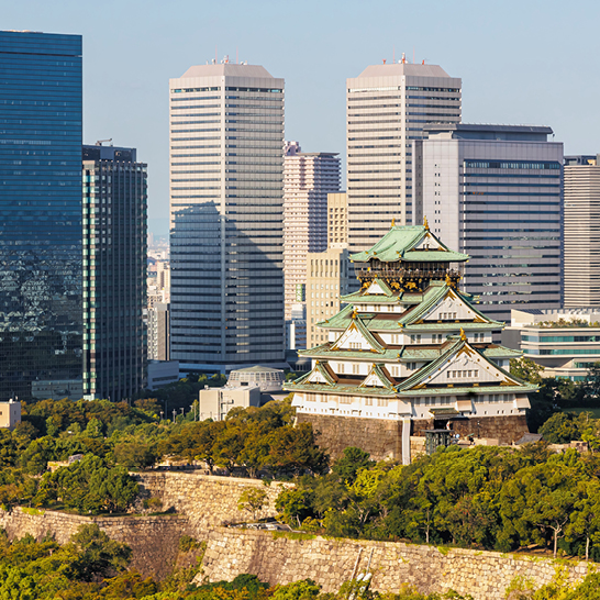 Stadtansicht mit einer grossen Gebäude im Vordergrund, die Vergangenheit und Zukunft Japans symbolisiert.