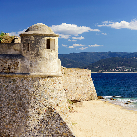 Eine hohe Steinmauer, die aus groben Steinen gebaut ist und Stabilität ausstrahlt.