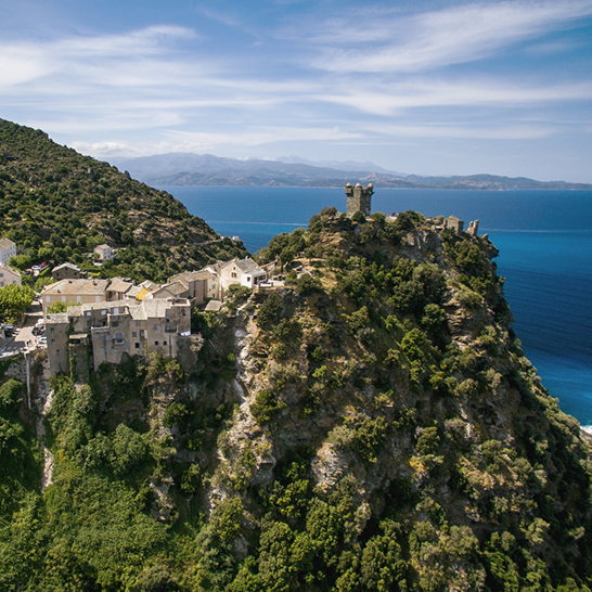 Malerisches Dorf auf einer Klippe, das den weiten Ozean überblickt.