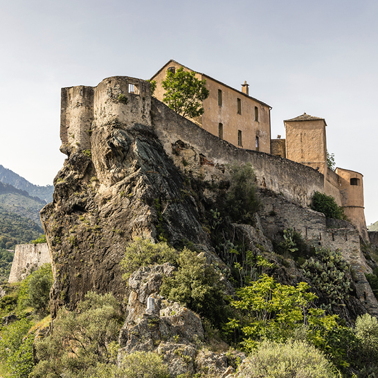 Ein imposantes Gebäude thront auf einem steinigen Hügel.