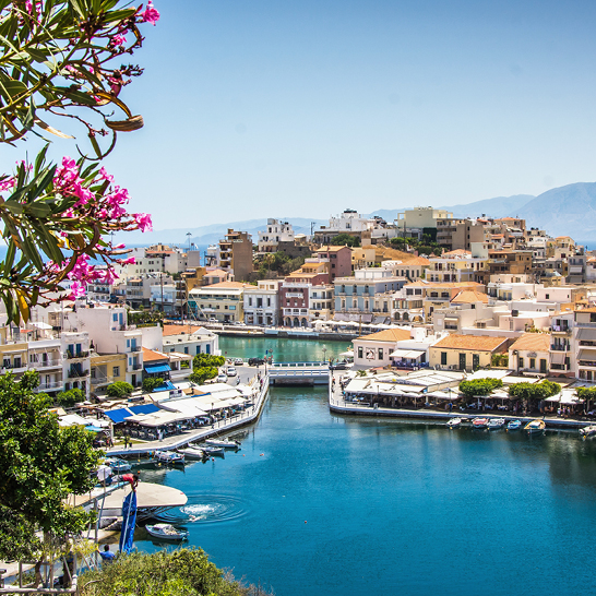 Ein ruhiger Wasserbereich in Agios Nikolaos, umgeben von sanften Hügeln und mediterraner Vegetation.