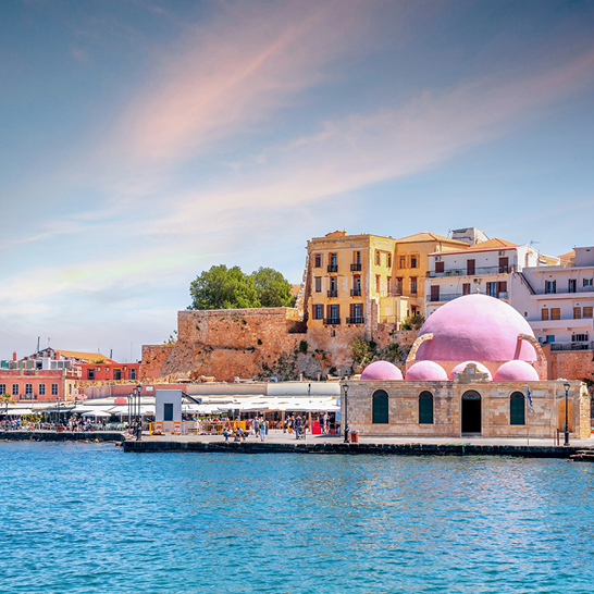 Eine pinke Kuppel auf einem Gebäude mit Blick auf das Wasser in Chania.