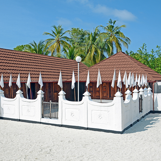 Bâtiment blanc orné de drapeaux blancs et bruns, créant un contraste élégant.