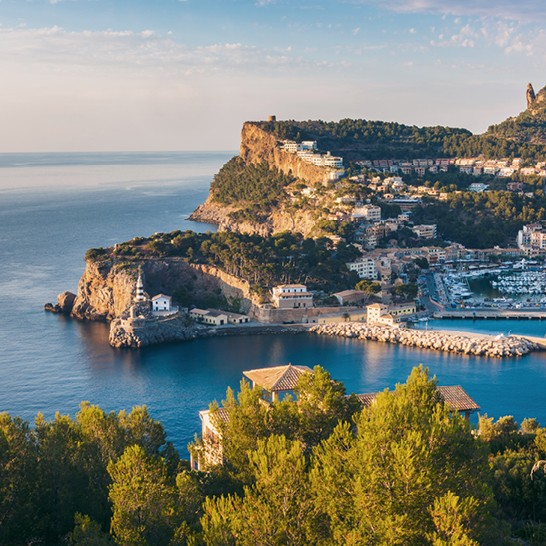 Blick auf eine malerische Bucht mit einem kleinen Küstendorf auf Mallorca.