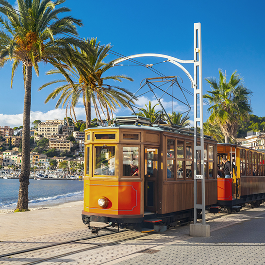 Soller Bahn Zug auf den Gleisen, umgeben von schöner Natur.