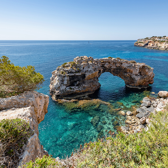 Grosse Felsformation Es Pontas im Ozean, umgeben von klarem Wasser und sanften Wellen.