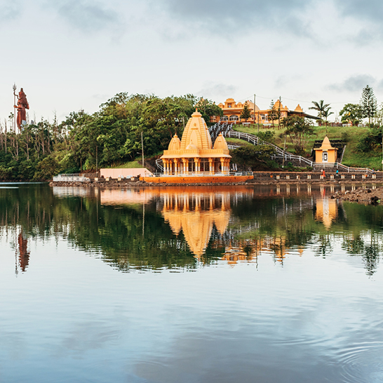 Reflet d'un temple dans l'eau, avec une colline en arrière-plan sur l'île Maurice.