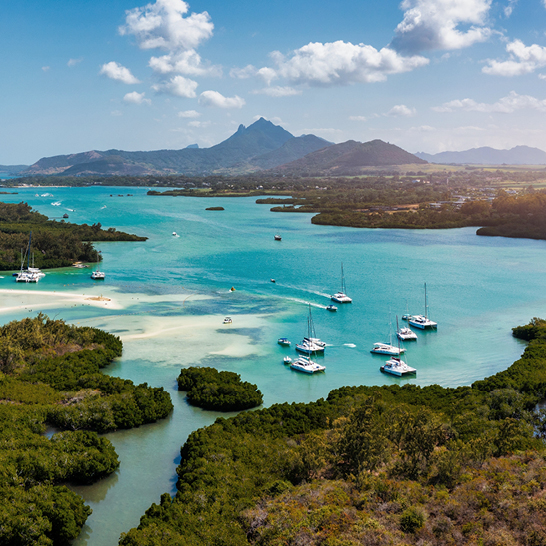 Un groupe de bateaux flottant paisiblement dans l'eau autour de l'île Maurice.