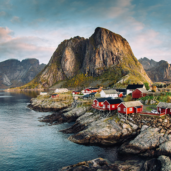 Vue magnifique d'un village côtier à Lofoten, avec des maisons colorées et des montagnes en arrière-plan.