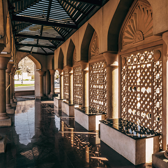 Langer Flur mit vielen gewölbten Fenstern, der Tradition und Modernität im Oman vereint.