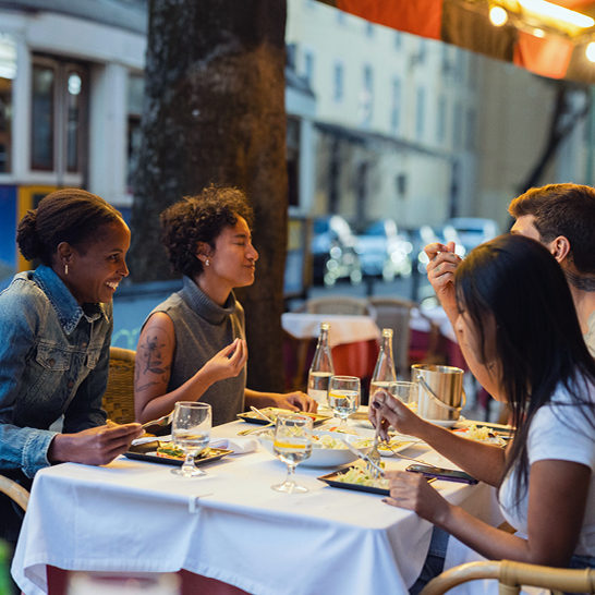Eine Gruppe von Menschen sitzt entspannt an einem Tisch und unterhält sich.