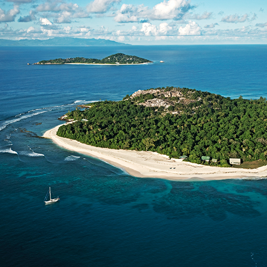 Une île des Seychelles avec du sable blanc et des eaux bleues cristallines.