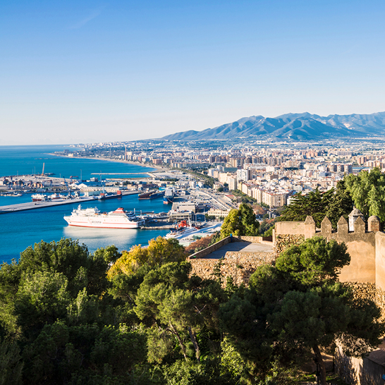 Blick auf den Hafen von Barcelona, Spanien, von der Spitze der Alcazaba aus, mit Segelbooten und der Stadt im Hintergrund.