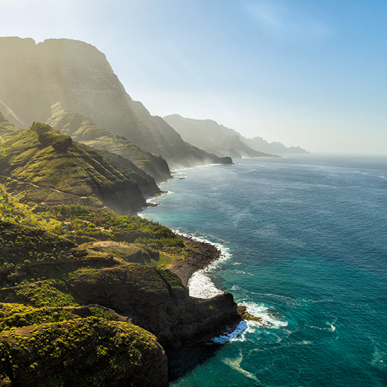 Weitläufiges Gewässer mit einer beeindruckenden Bergkette im Hintergrund, aufgenommen in Spanien.