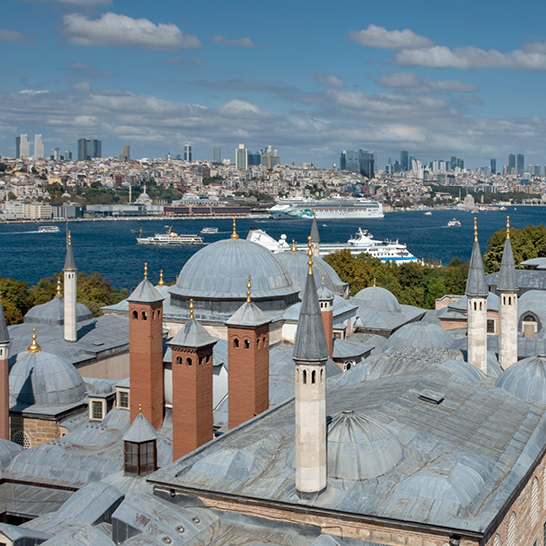 Blick auf eine türkische Stadt mit vielen Gebäuden und einem Fluss, der durch die Landschaft fliesst.