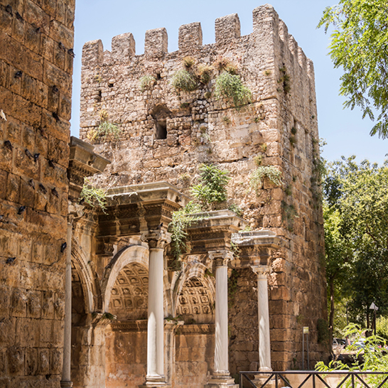 Steingebäude mit Säulen und einem Uhrturm in Antalya.