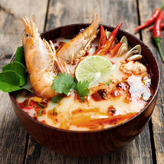 Soupe thaï avec des crevettes et des légumes dans un bol.