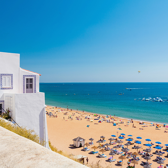 Weisses Gebäude mit blauen Sonnenschirmen in Albufeira.
