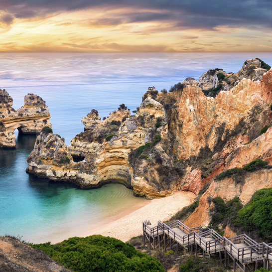 Wunderschöne Landschaft von Lagos, Algarve, Portugal, bei Sonnenuntergang mit warmen Farben und sanften Hügeln.