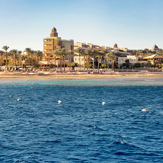 Ein Boot segelt im Ozean nahe einem Strand in Hurghada.