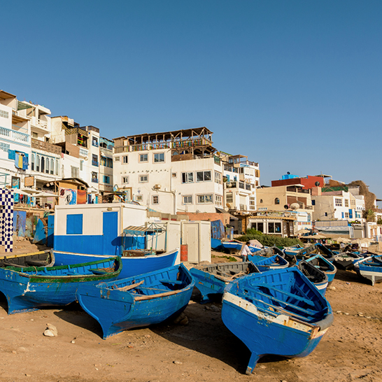 Blaue Holzboote am Ufer im Dorf Taghazout in Marokko.